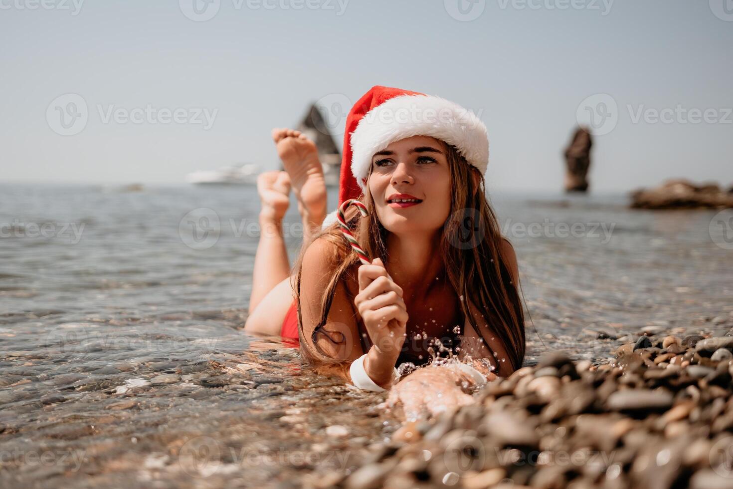 vrouw reizen zee. gelukkig toerist genieten nemen afbeelding Aan de strand voor herinneringen. vrouw reiziger in de kerstman hoed looks Bij camera Aan de zee baai, sharing reizen avontuur reis foto