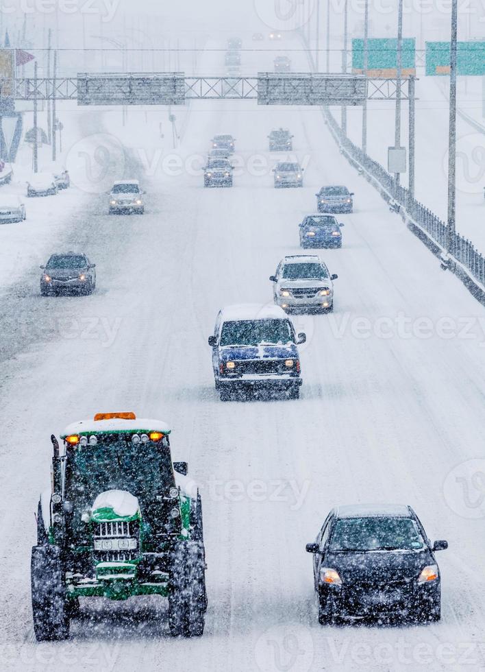 sneeuwploegen en auto's op de snelweg foto
