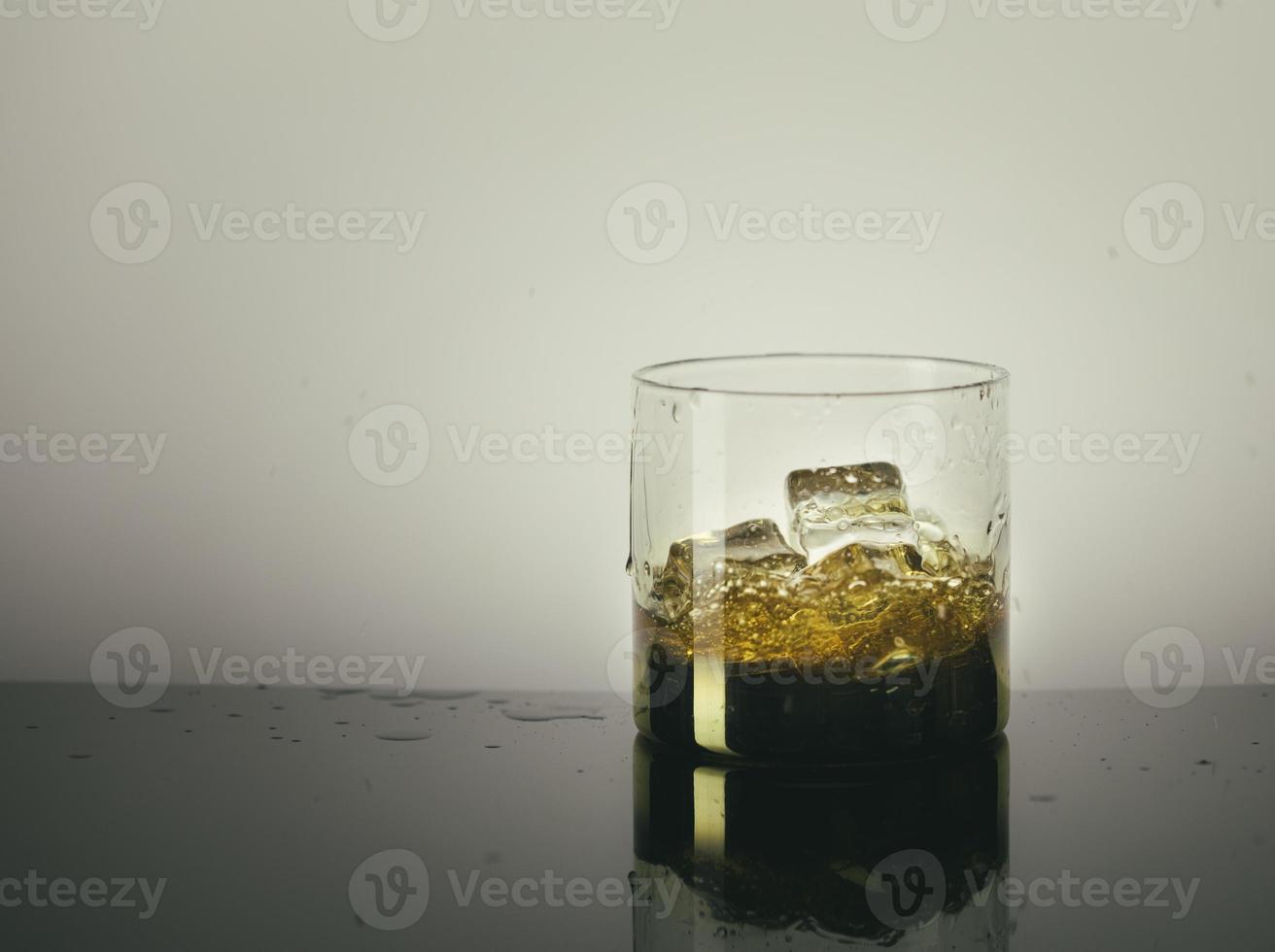 spetterend glas single malt whisky over grijze achtergrond foto