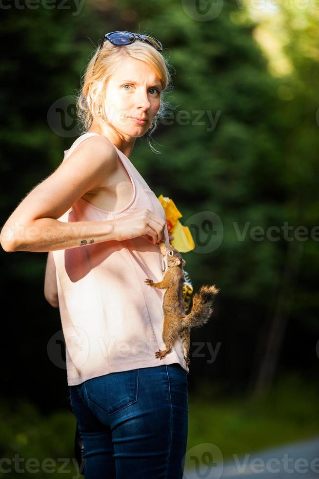 grappige close-up van een vrouw die een rode eekhoorn voedt foto