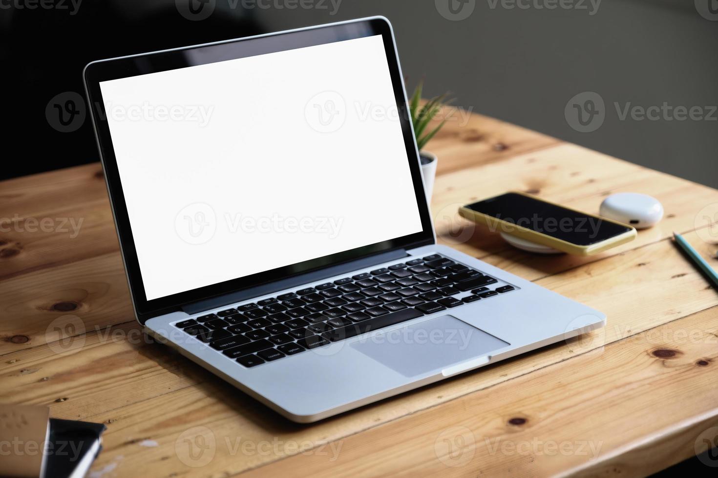 close-up laptop op houten bureau achtergrond wazig. laptopcomputer met leeg scherm en kan uw teksten of anderen op laptop toevoegen foto