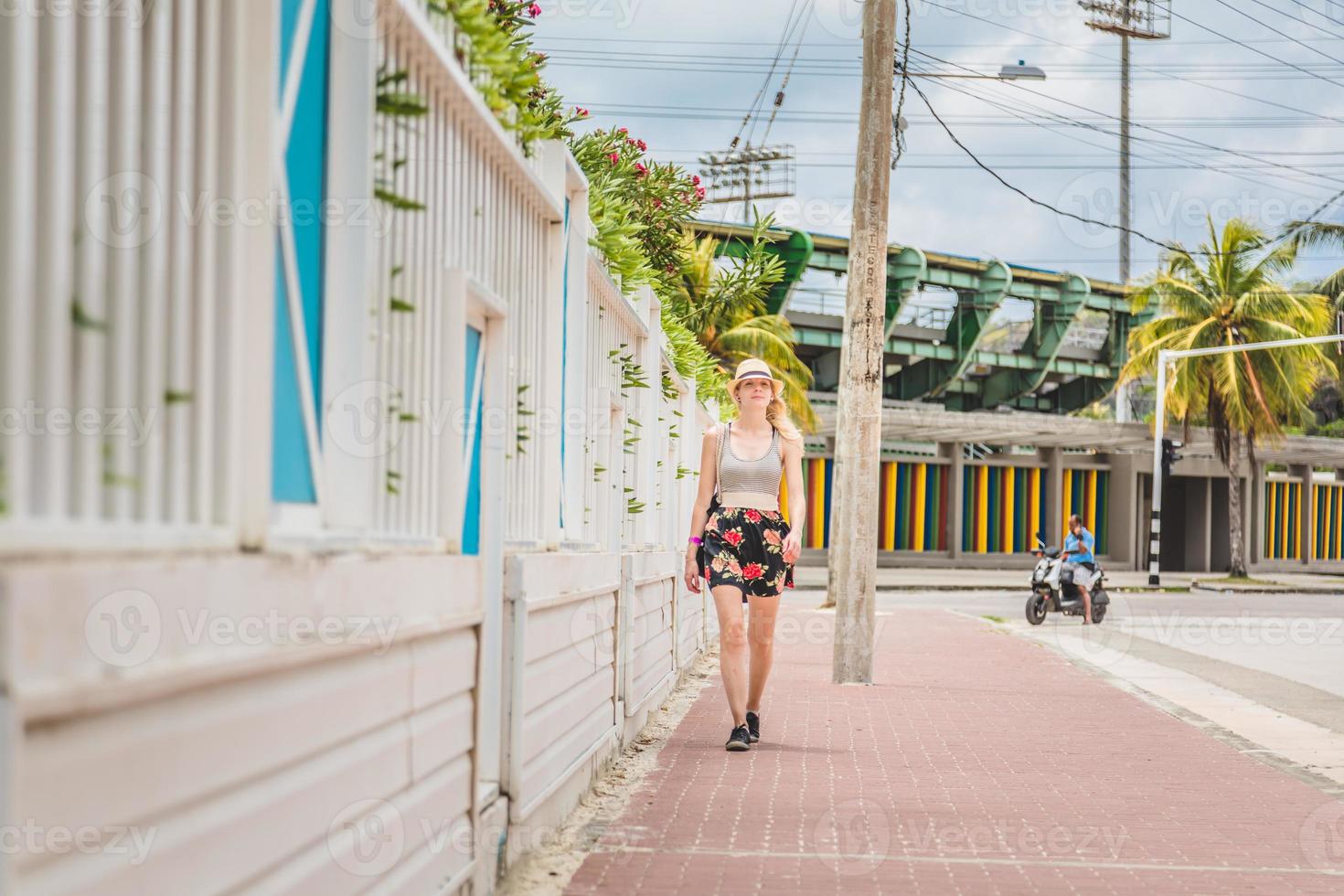 jonge blonde vrouw in vakantie wandelen in de Caribische straat foto