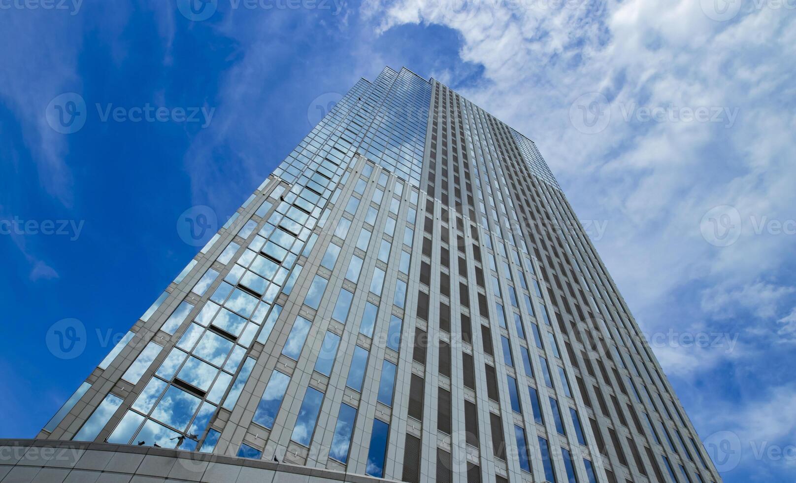 een wolk reflecterend de gebouw in de bedrijf stad- breed schot foto