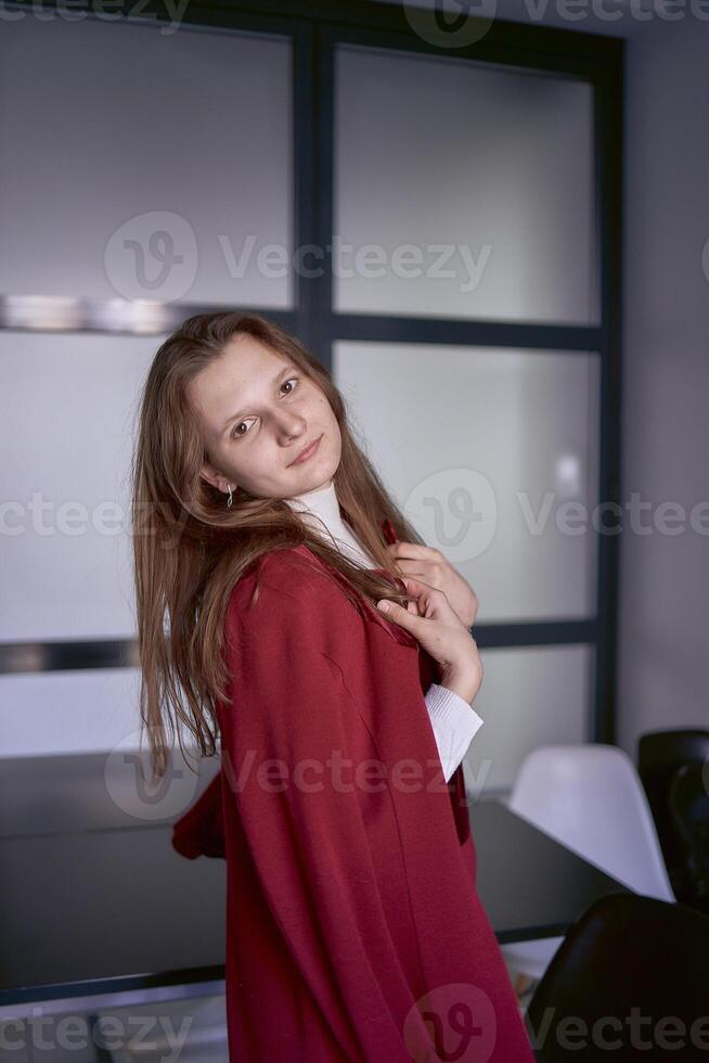 portret van een jong vrouw in een rood kantoor pak foto