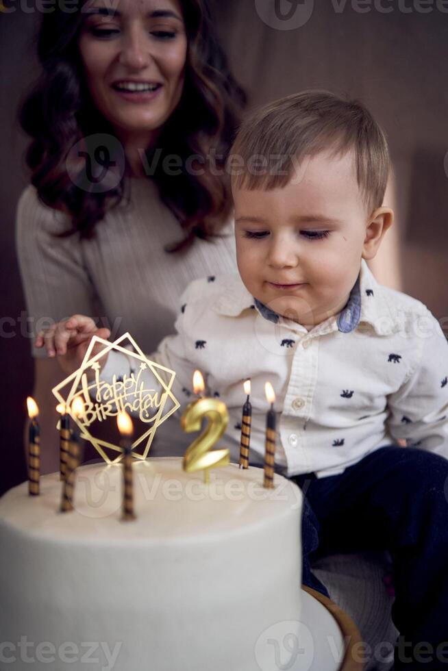 emotioneel ouders kijk maar net zo hun zoon slagen uit de kaarsen Aan de verjaardag taart foto