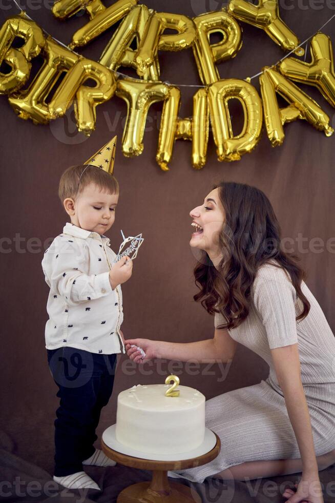 heel emotioneel mam en haar weinig verjaardag jongen aan het eten taart foto