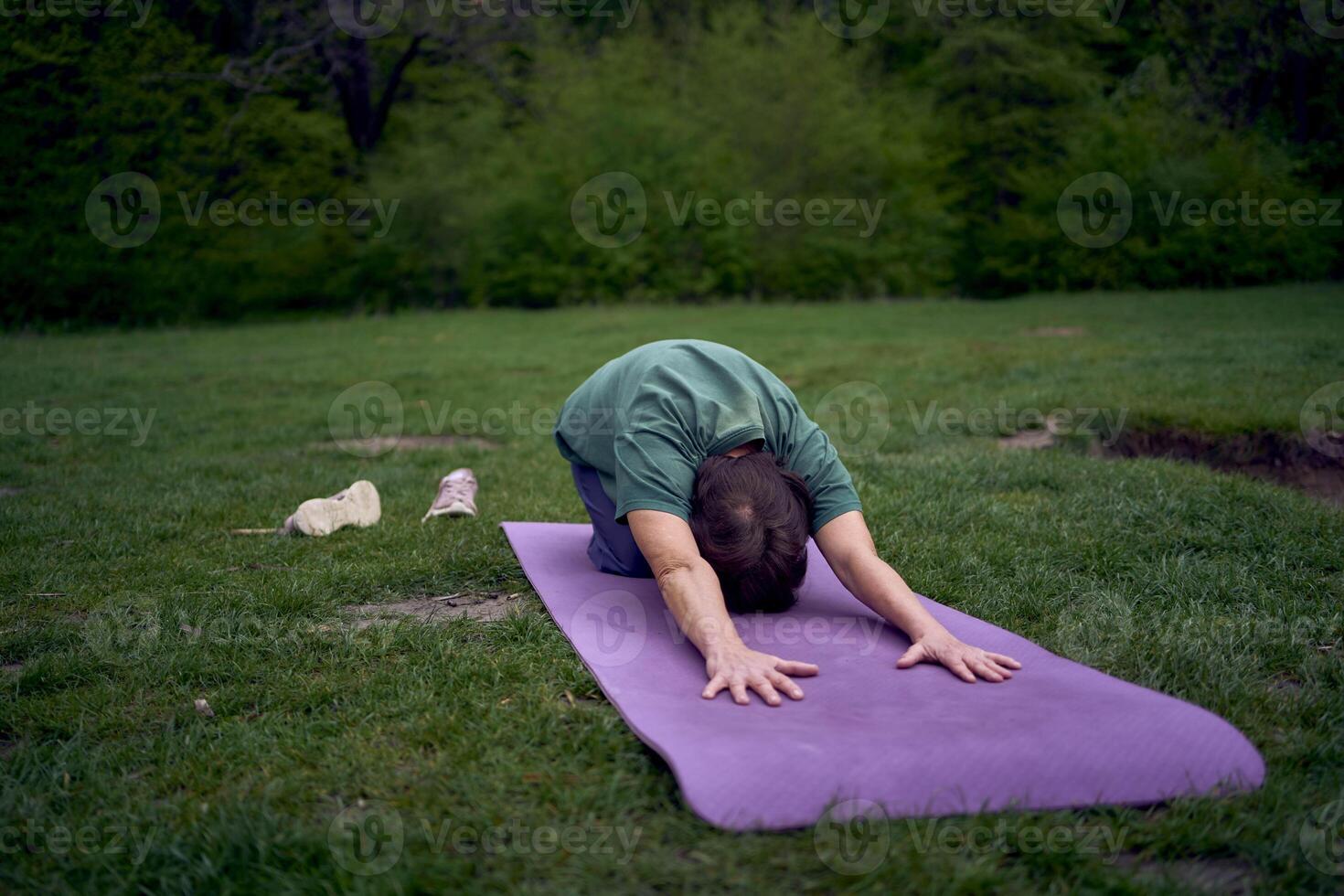 oud vrouw praktijken yoga in de ochtend- Aan de rivier- bank, kwam van huis door fiets foto