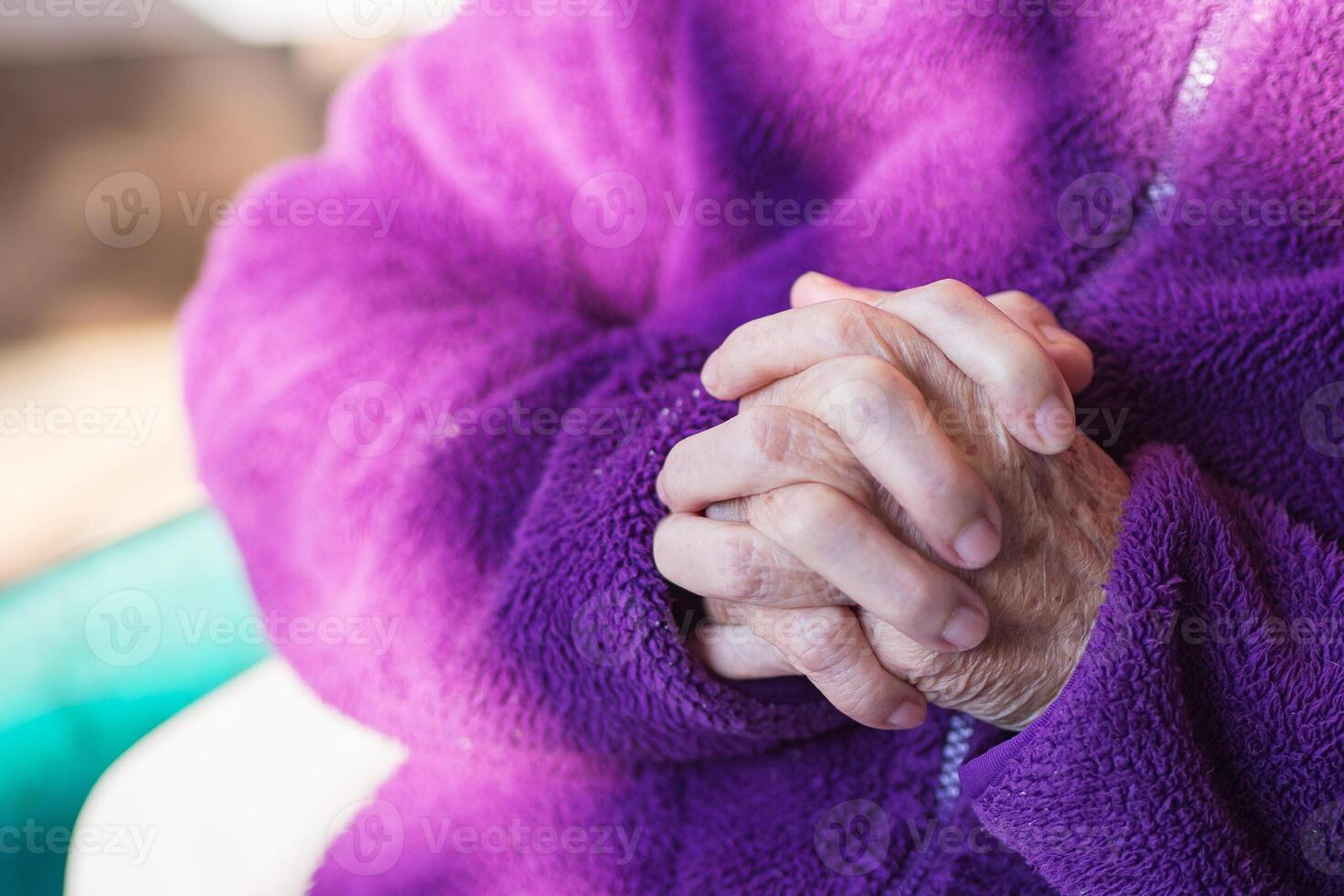detailopname van senior vrouw handen bidden terwijl zittend Aan een stoel Bij huis foto