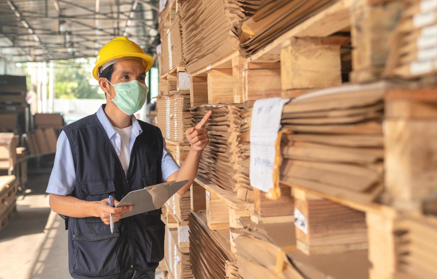 arbeider die grondstoffeninventaris in fabriek controleert; foto