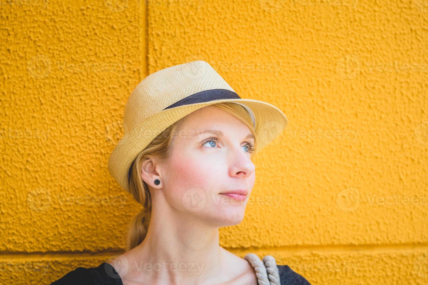 portret van een gelukkige blonde blanke vrouw voor gele achtergrond foto