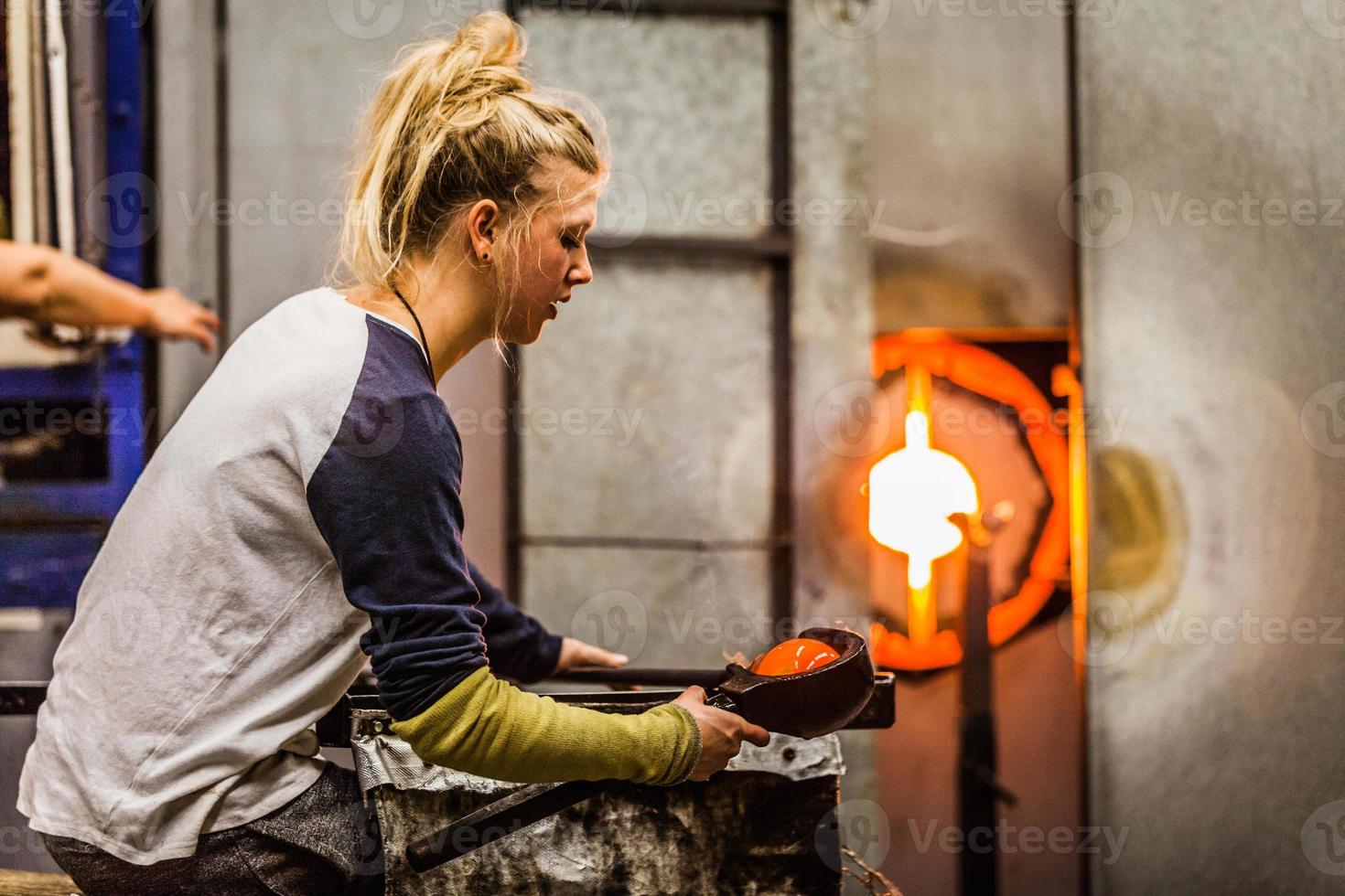 blazende glas professionele vrouw die aan een vaas werkt. foto