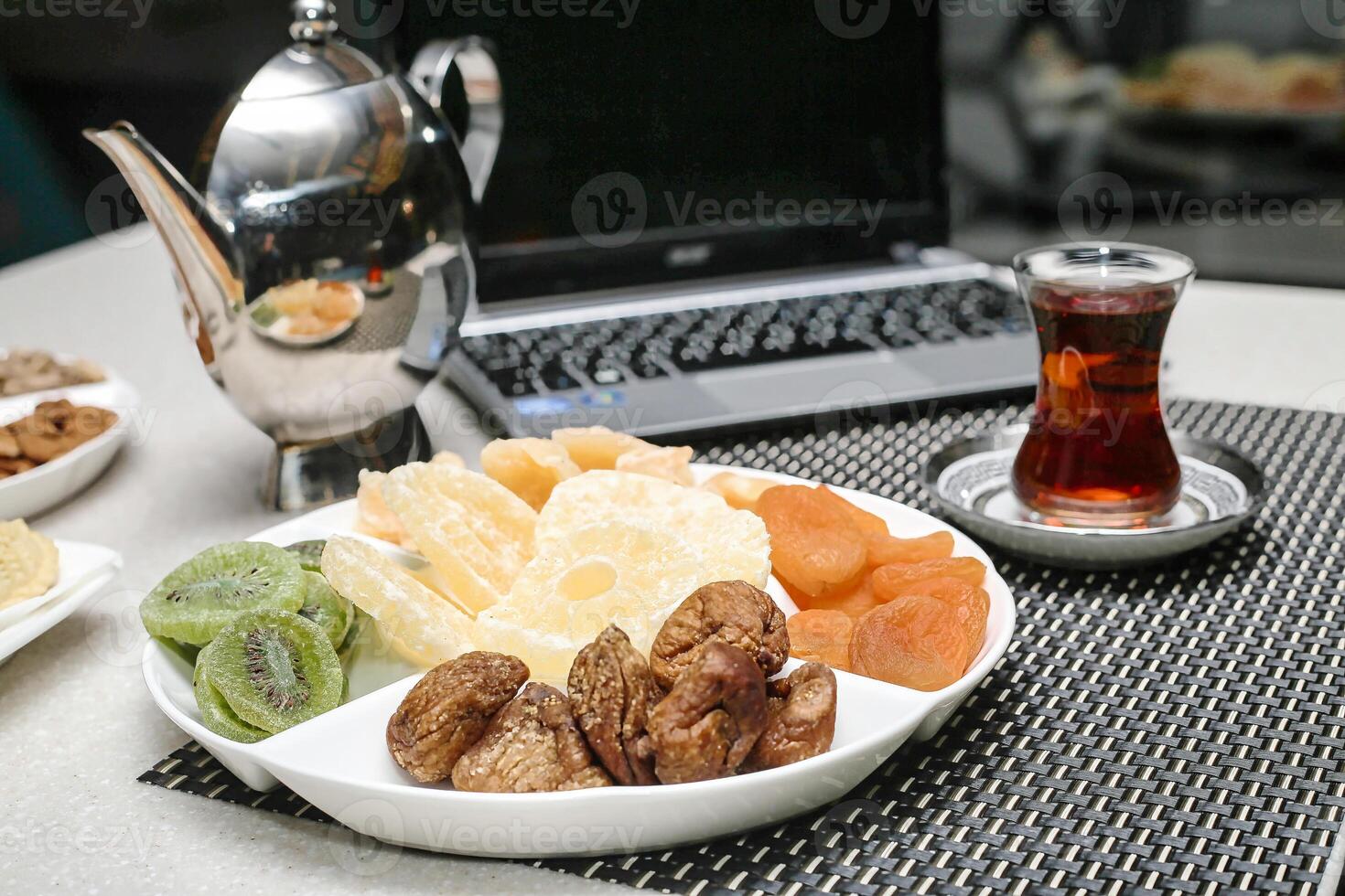 bord van geassorteerd fruit en noten met een kop van thee foto