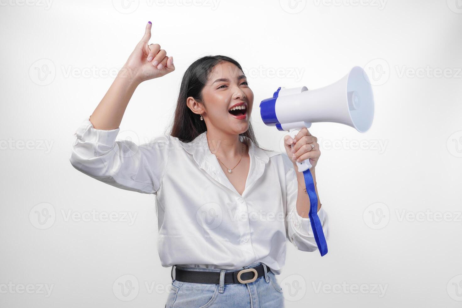 opgewonden Aziatisch vrouw in gewoontjes formeel kleding Holding en geschreeuw Bij megafoon, richten weinig vinger gedoopt in Purper inkt na stemmen voor Indonesië verkiezing, staand Aan geïsoleerd wit achtergrond foto