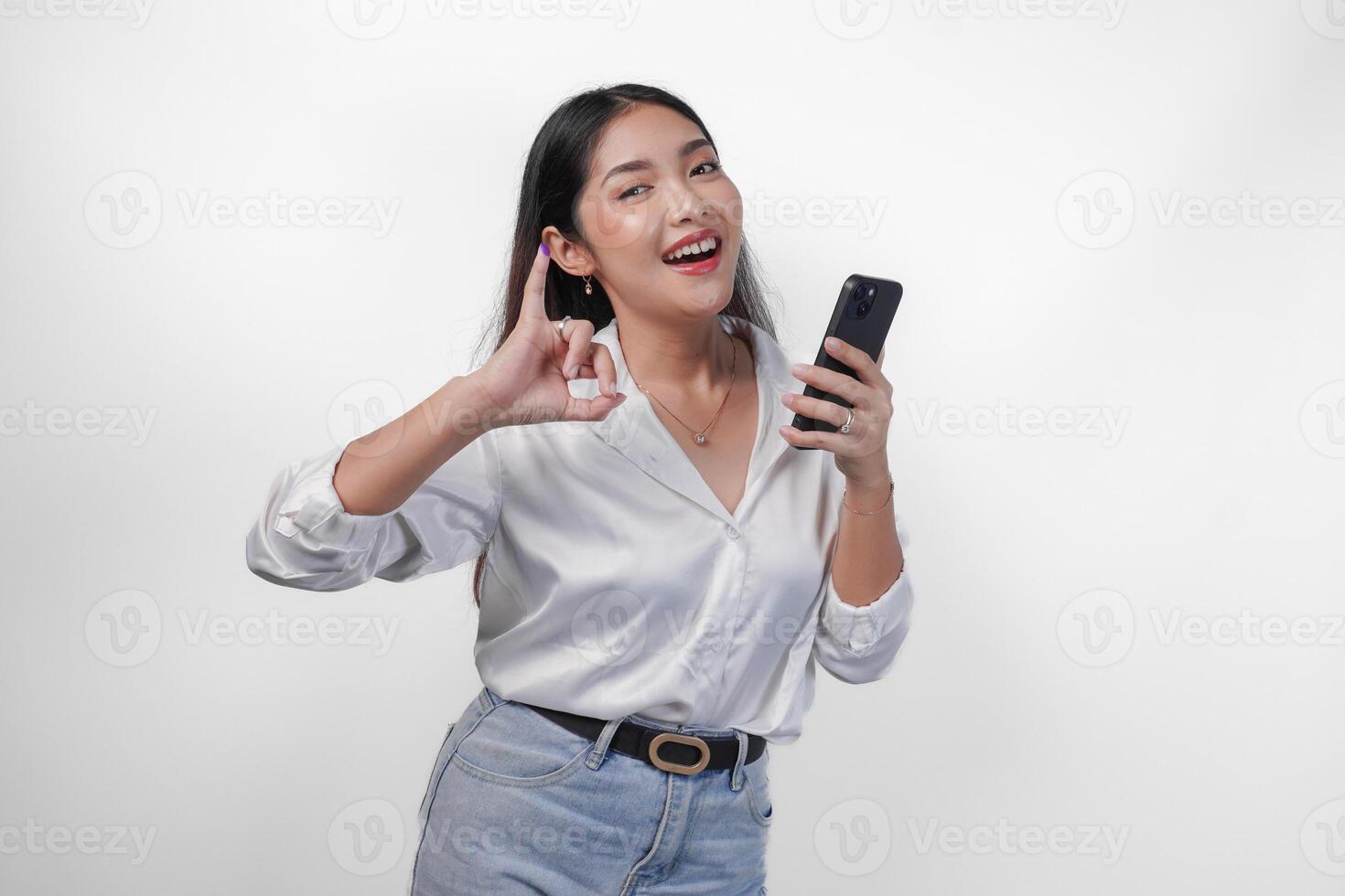 vrolijk Aziatisch vrouw trots tonen weinig vinger gedoopt in Purper inkt na stemmen voor president en parlement verkiezing terwijl links hand- Holding telefoon, uitdrukken opwinding en geluk foto