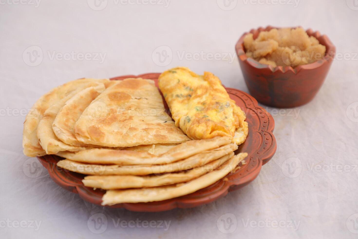 desi ontbijt omelet, halwa en paratha geserveerd in schotel geïsoleerd Aan achtergrond top visie van banglades ontbijt foto