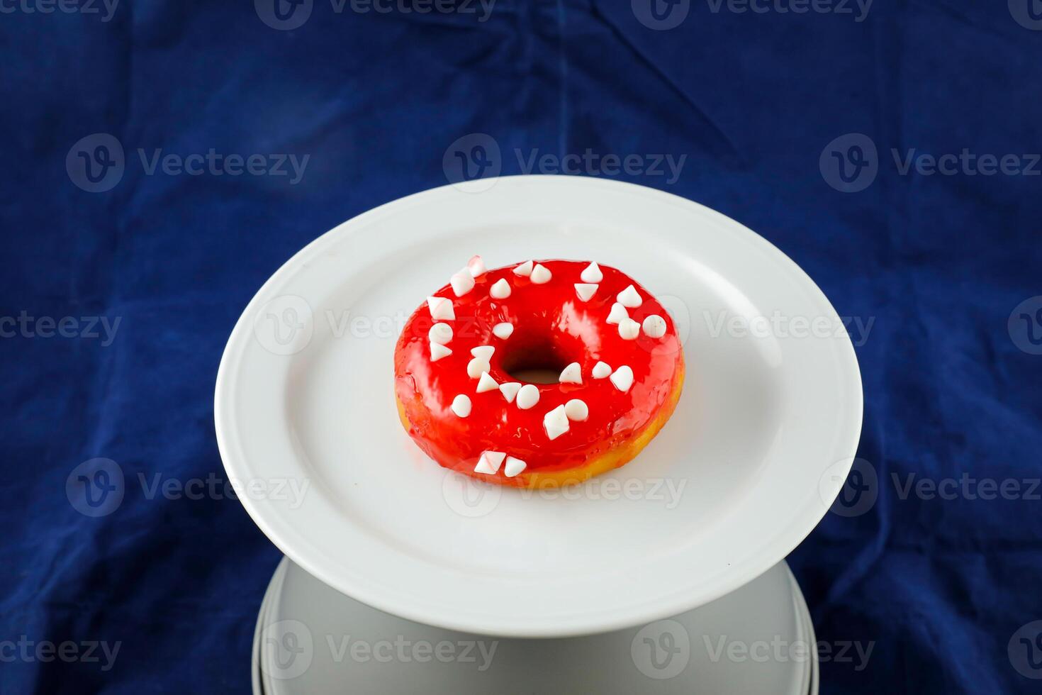 aardbei geglazuurd donut geserveerd in bord geïsoleerd Aan blauw achtergrond kant visie van gebakken voedsel ontbijt Aan tafel foto