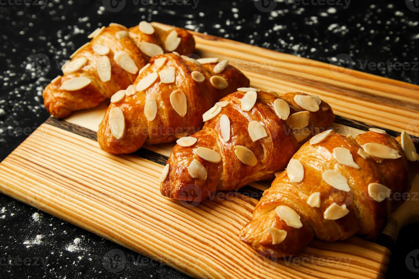 amandel croissant topping met noten geserveerd Aan houten bord kant visie van Frans ontbijt gebakken voedsel item foto