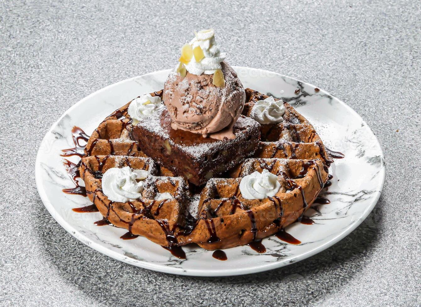 brownie wafel met ijs room lepel geserveerd in schotel geïsoleerd Aan achtergrond top visie van hong Kong toetje voedsel foto