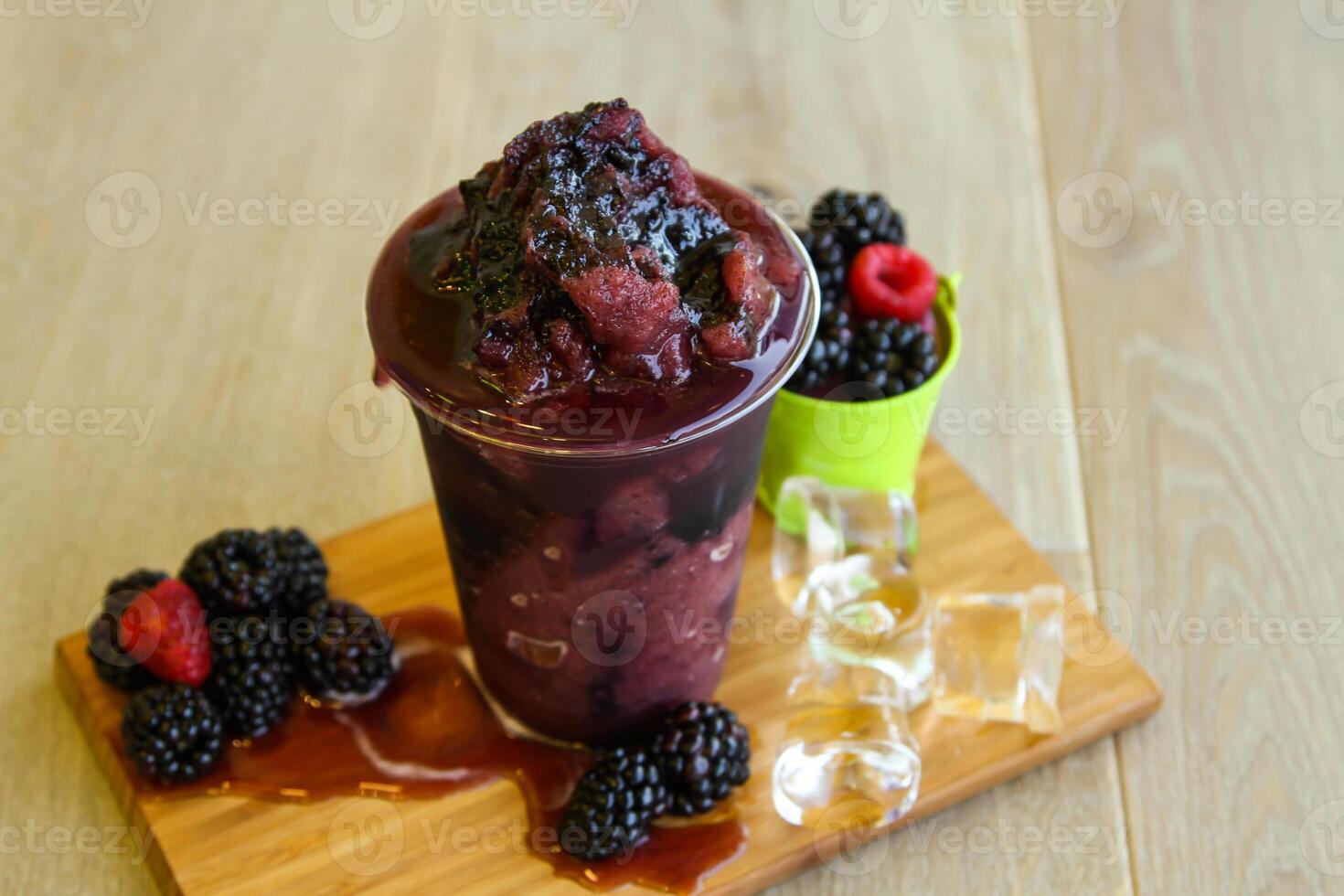 framboos en moerbei smoothie met ijs kubus geserveerd in beschikbaar glas geïsoleerd Aan tafel kant visie van gezond ochtend- smoothie drinken foto