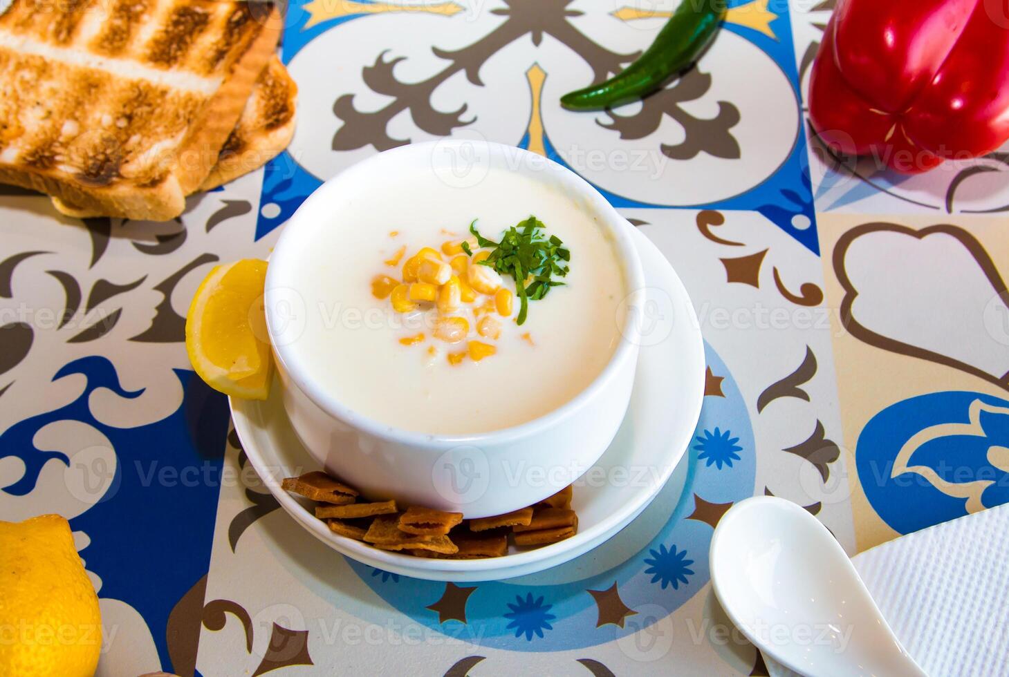 maïs soep met limoen, lepel, crackers en brood geserveerd in schotel geïsoleerd Aan tafel top visie van Arabisch voedsel foto