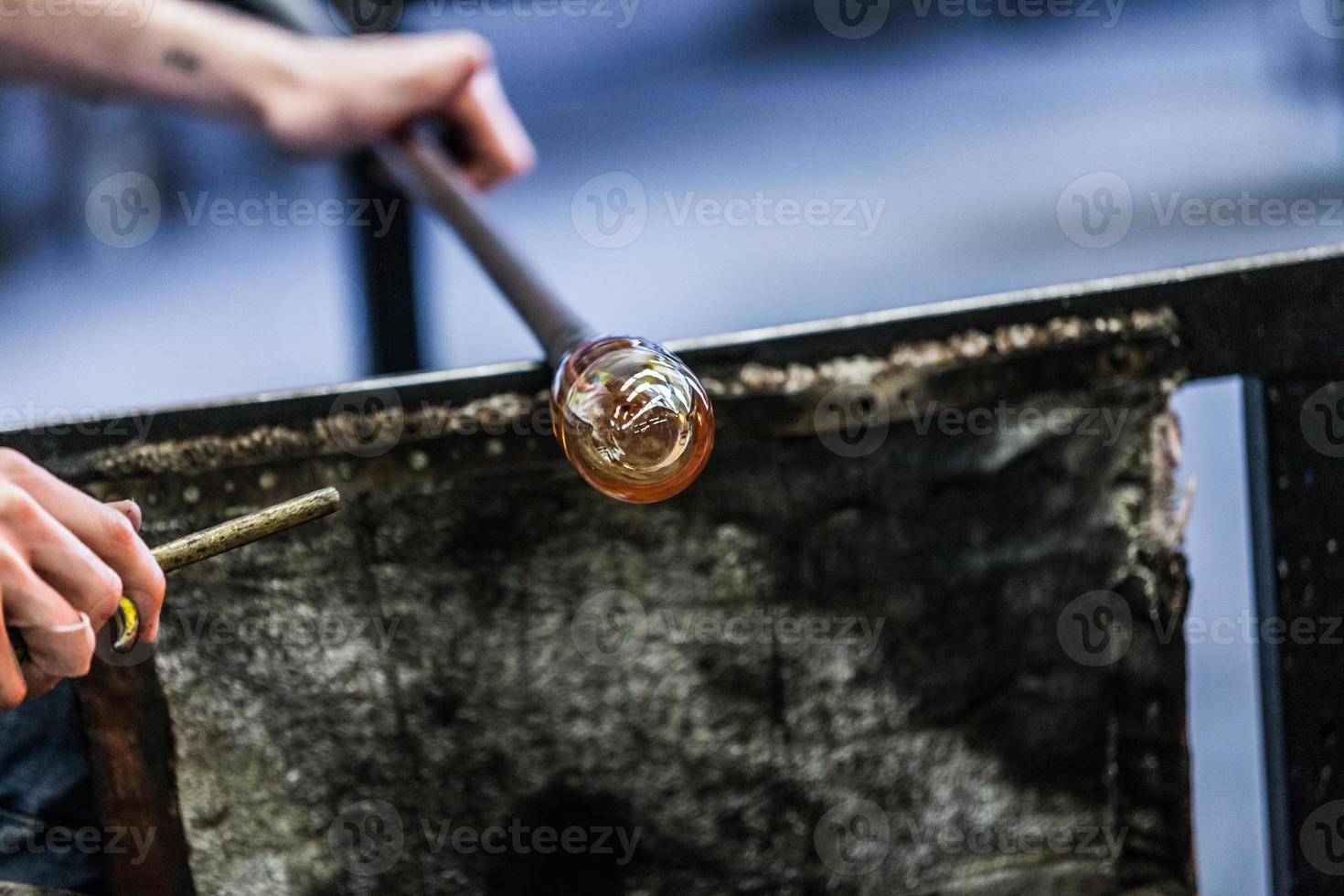 man handen close-up werken aan een stuk geblazen glas foto