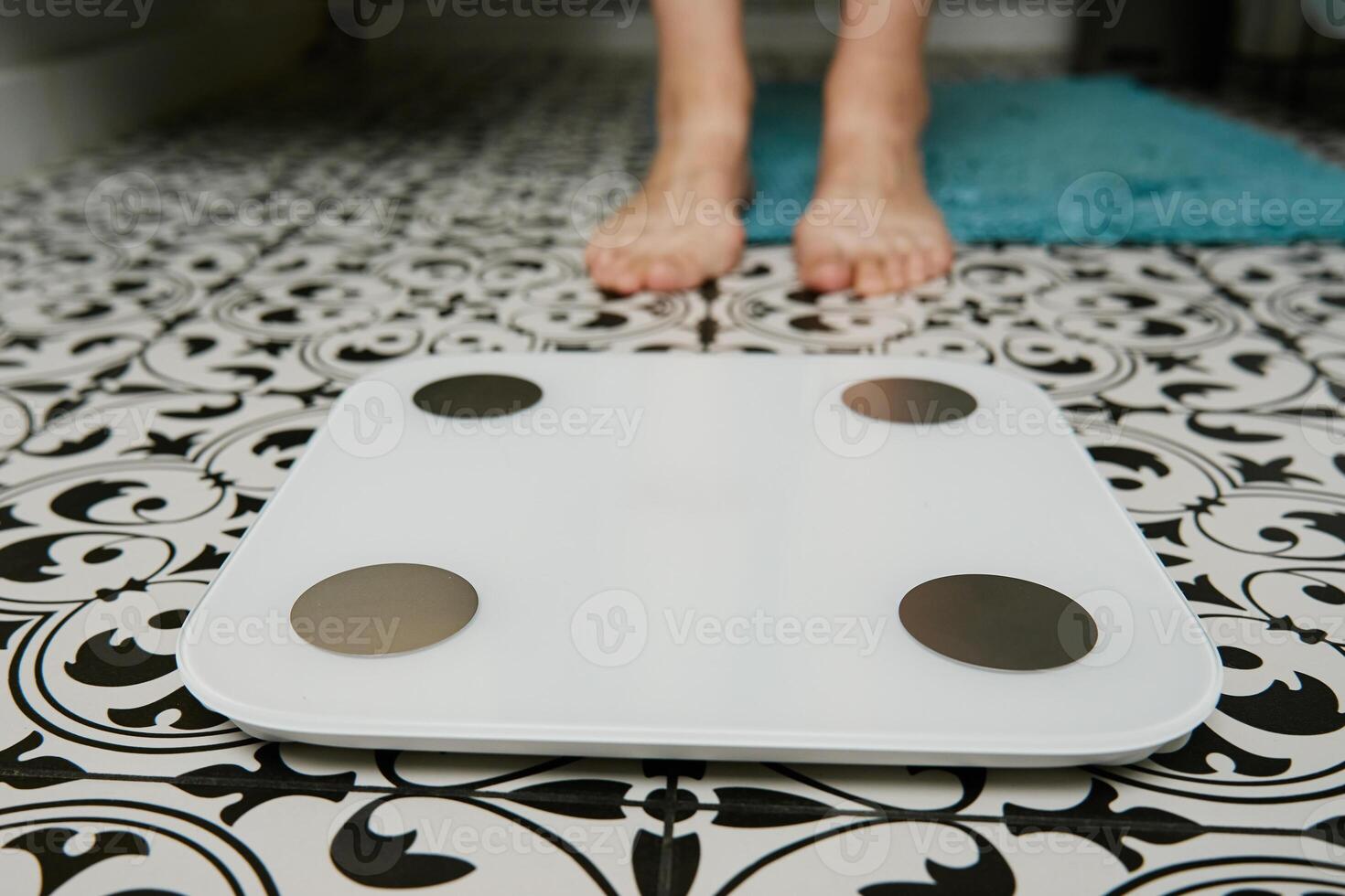 vrouw controle haar gewicht Aan weging balans in badkamer foto