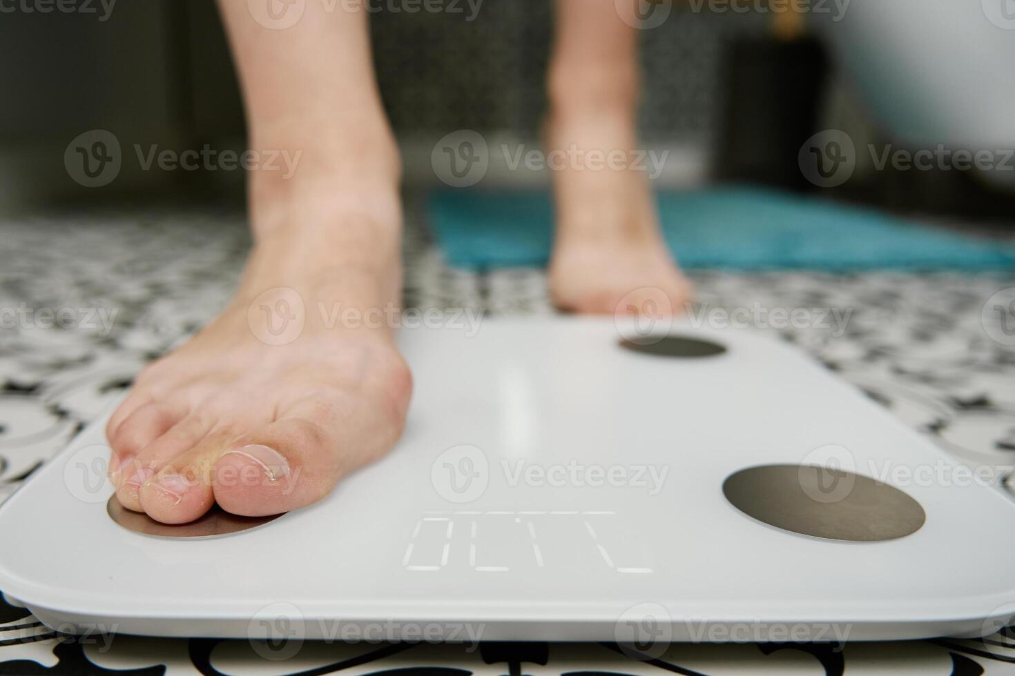 vrouw controle haar gewicht Aan weging balans in badkamer foto