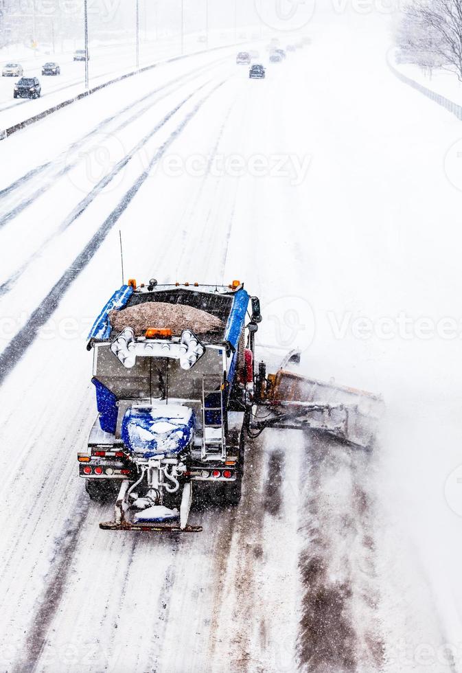 sneeuwploeg die de sneeuw van de snelweg verwijdert tijdens een sneeuwstorm foto