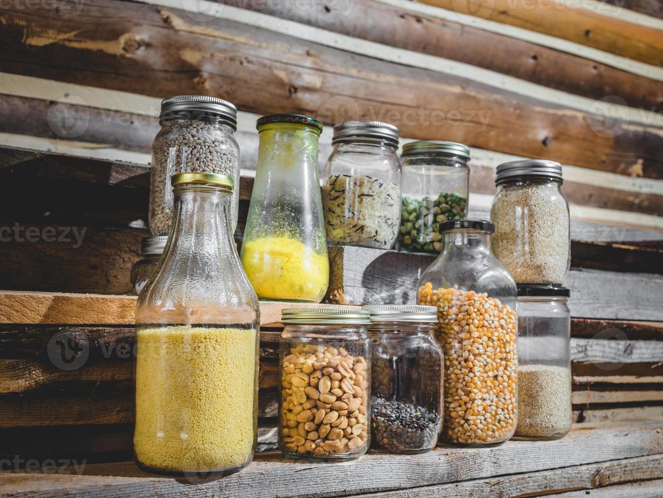 glazen potten met kruiden, granen en droogvoer foto