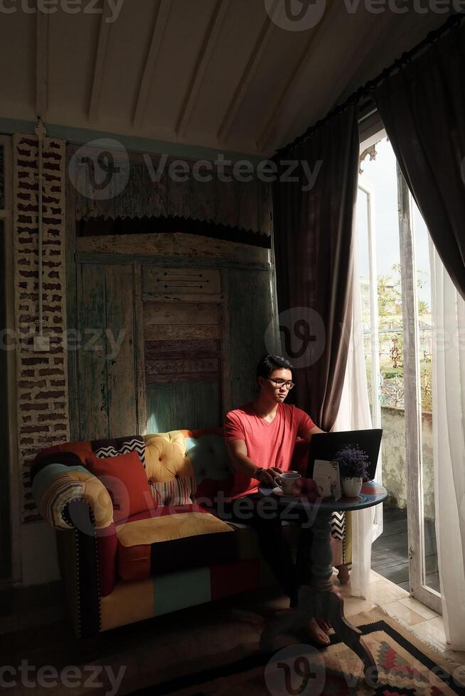 villa ontspanning, Aziatisch model- werken Aan laptop, genieten in zonovergoten comfort foto