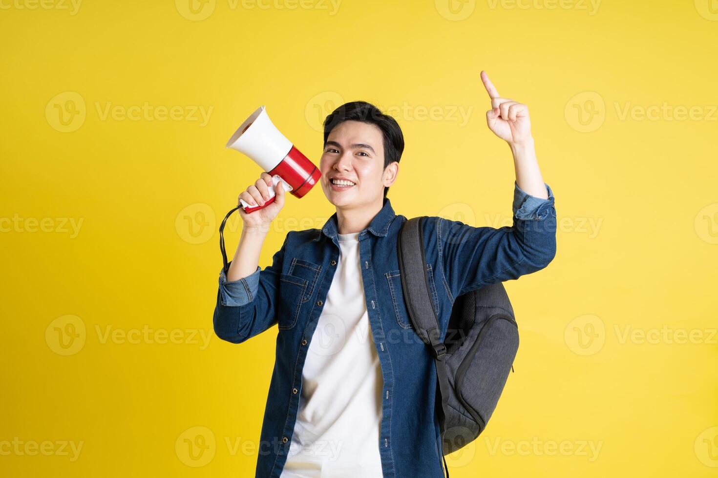 portret van Aziatisch mannetje leerling poseren Aan geel achtergrond foto