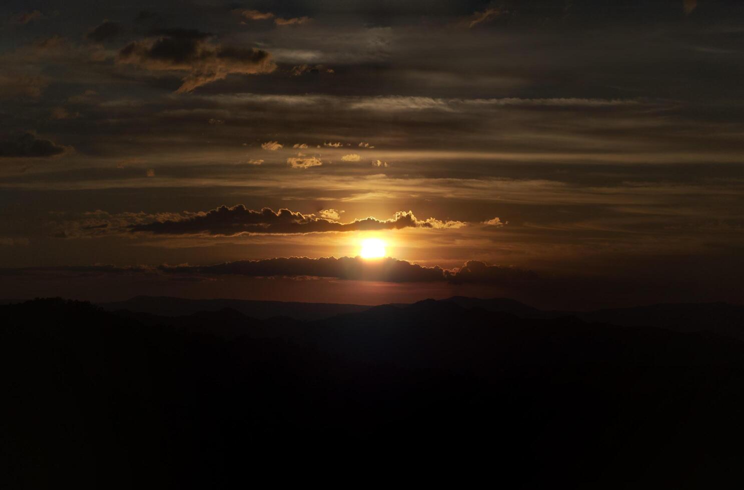 de verbijsterend visie van een toeristen standpunt net zo ze Gaan naar beneden een heuvel Aan een mistig spoor met een heuvel en een achtergrond van een gouden lucht in Woud park, Thailand. vogel oog visie. antenne visie. regenwoud foto