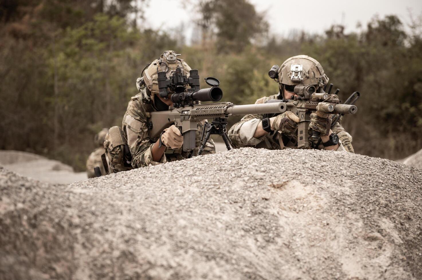 soldaten in camouflage uniformen het richten met hun geweren gereed naar brand gedurende leger operatie in de woestijn soldaten opleiding in een leger operatie foto