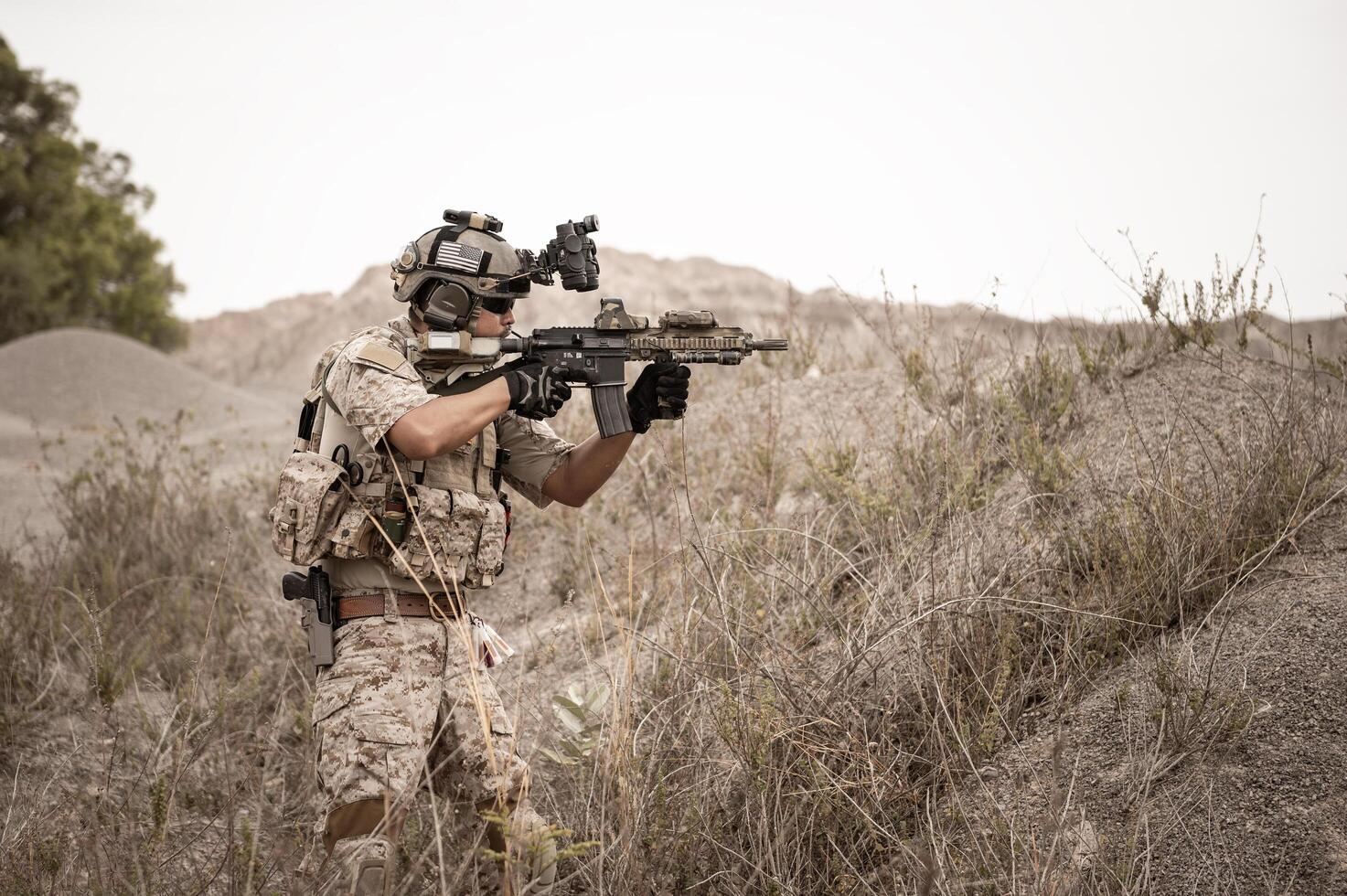 soldaten in camouflage uniformen het richten met hun geweren gereed naar brand gedurende leger operatie in de woestijn soldaten opleiding in een leger operatie foto