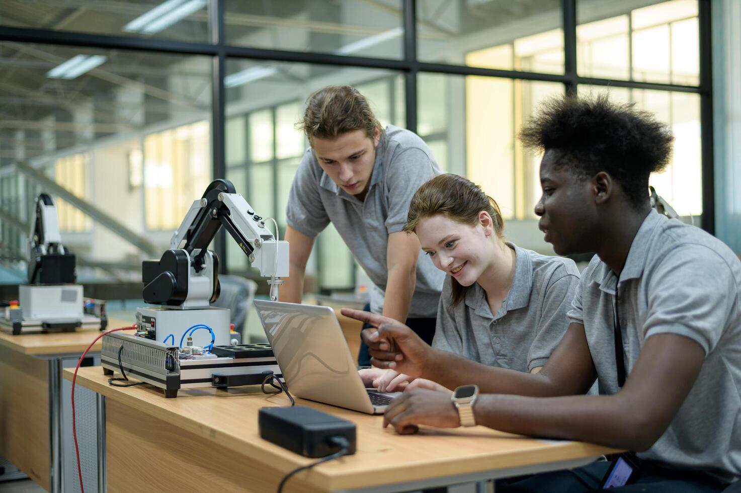 stagiair robotica ingenieur aan het leren met programmering en manipuleren robot hand, industrieel robotica ontwerp, hoog tech faciliteit, modern machine aan het leren. massa productie automaten. foto