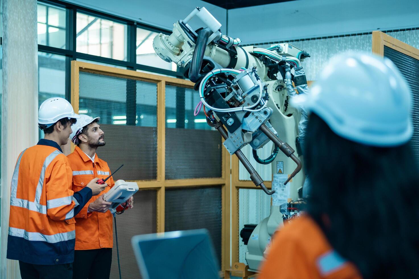 een groep van robotica ingenieurs werken met programmering en manipuleren robot hand, industrieel robotica ontwerp, hoog tech faciliteit, modern machine aan het leren. massa productie automaten. foto