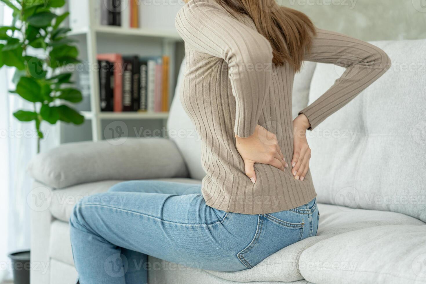 vrouw Holding haar lager terug terwijl en lijden van ondraaglijk pijn Gezondheid en problemen, chronisch terug pijn, rugpijn in kantoor syndroom, scoliose, hernia schijf, spier ontsteking foto