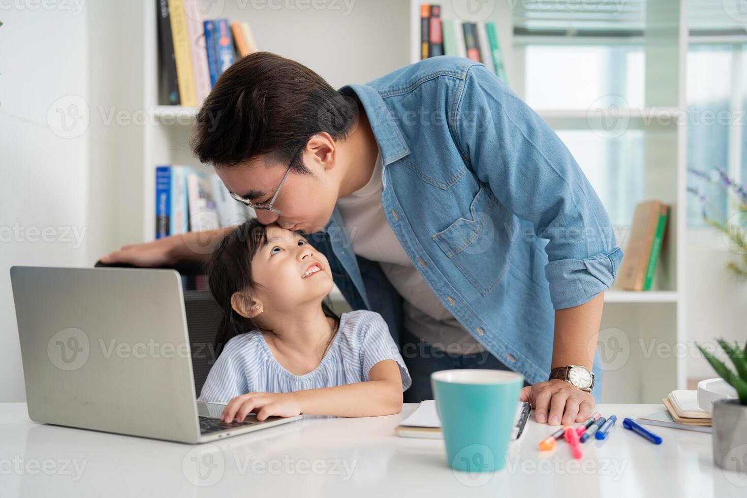 foto van Aziatisch vader en dochter aan het studeren Bij huis