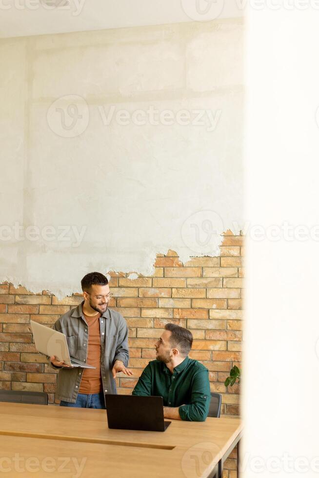 samenwerking in beweging, professionals werken samen in een modern met bakstenen muren kantoor foto