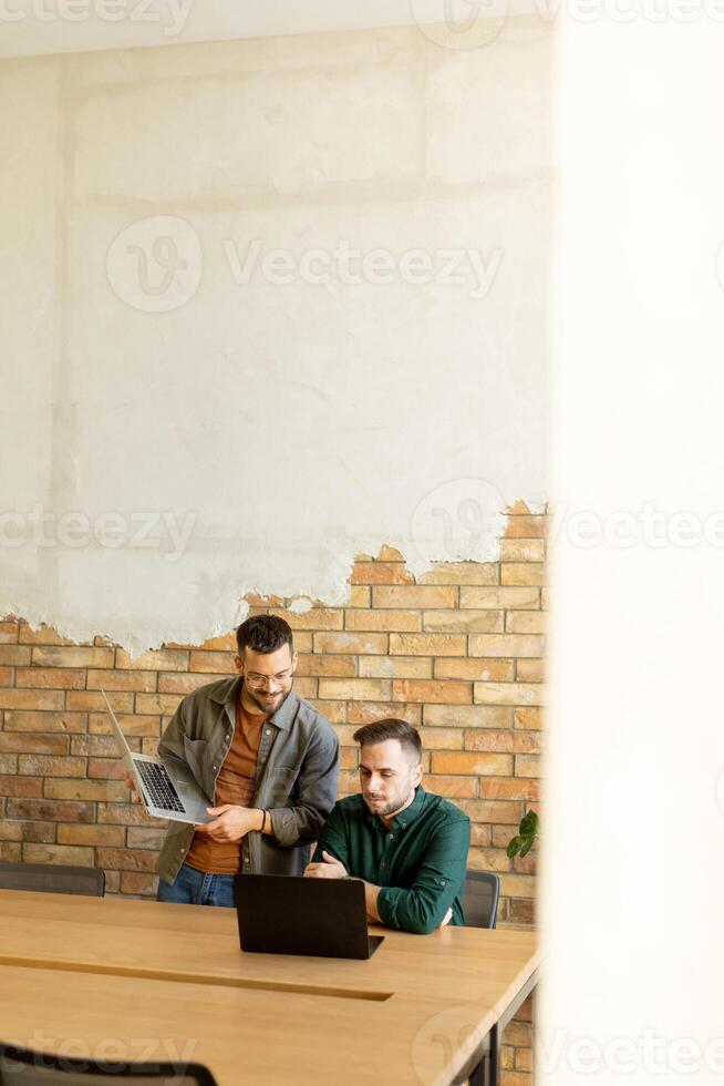 samenwerking in beweging, professionals werken samen in een modern met bakstenen muren kantoor foto
