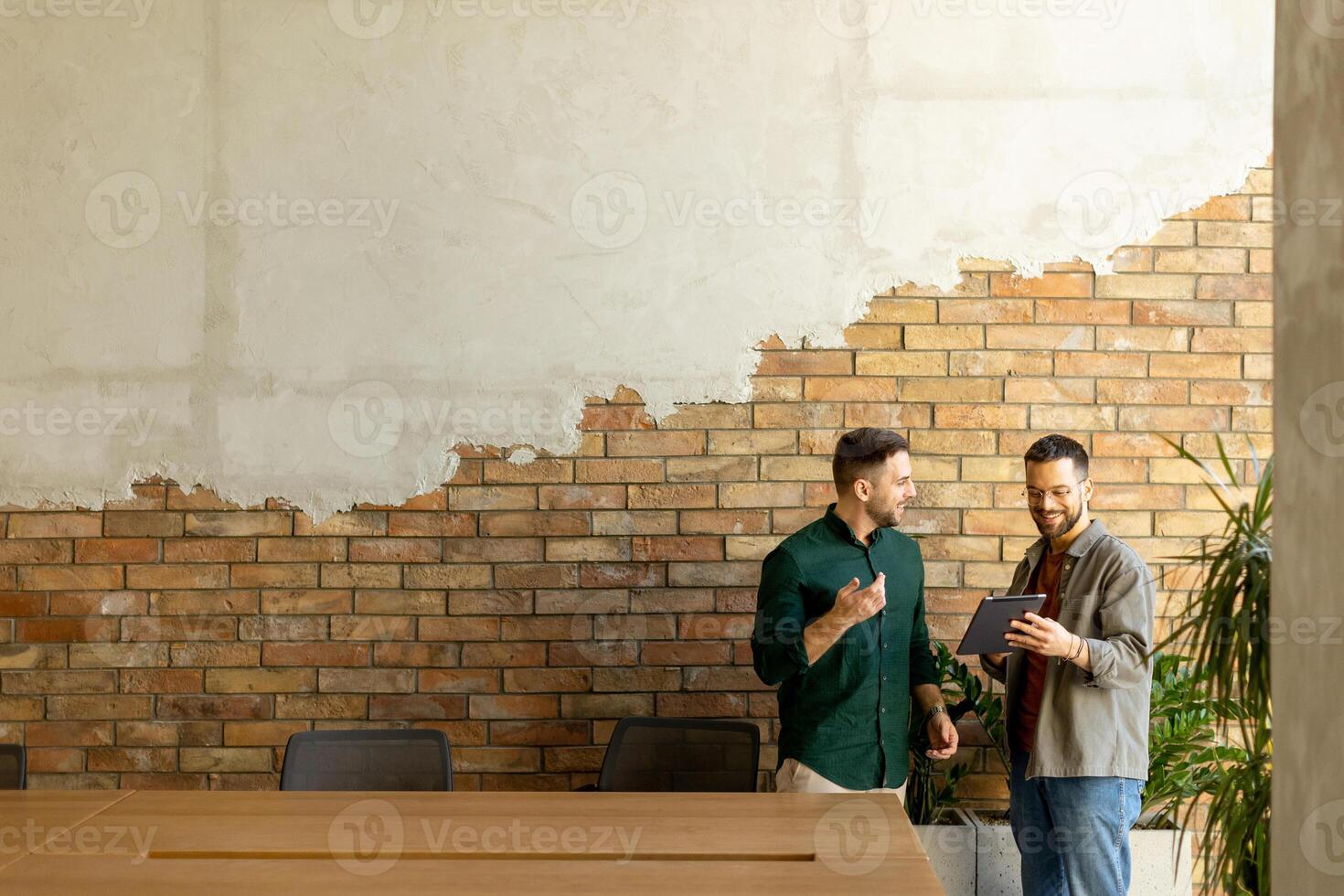 samenwerkend discussie in een modern kantoor met blootgesteld steen muren foto