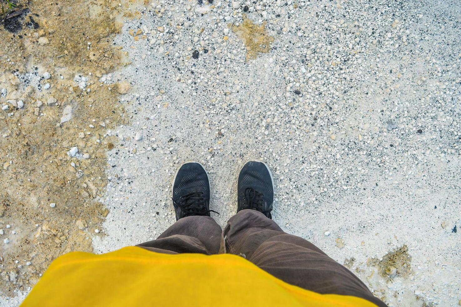 de voeten van een persoon vervelend joggingbroek staand Aan wit kalksteen rotsen foto