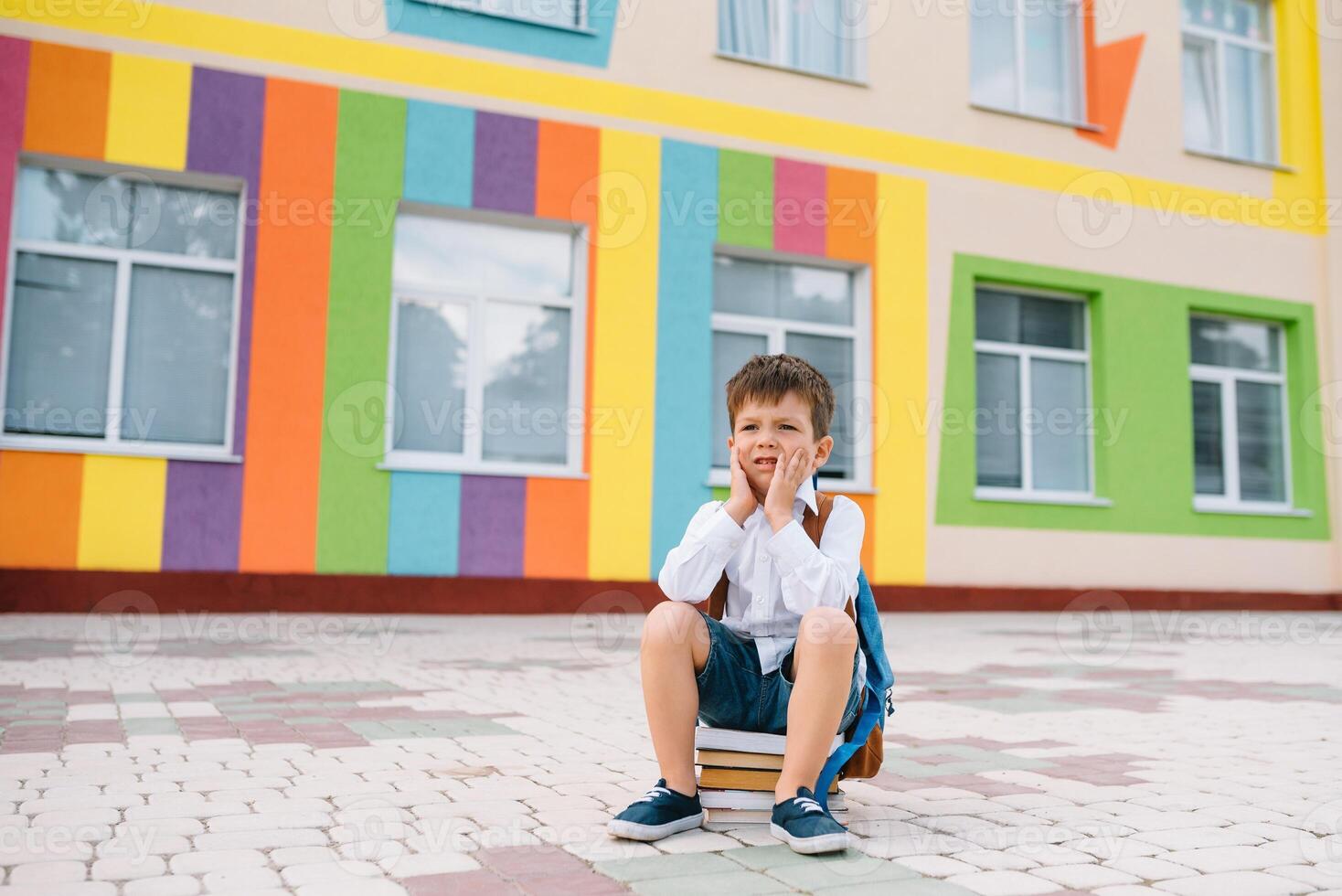 weinig jongen gaan terug naar school. kind met rugzak en boeken Aan eerste school- dag. terug visie. school- concept. terug naar school. foto