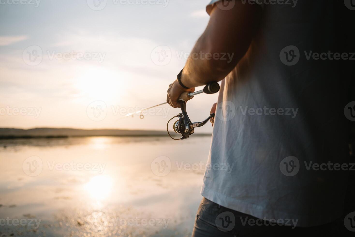de vissers handen, houdt de spinnen hengel, draait de spoel handvat. hobby en werkzaamheid. foto