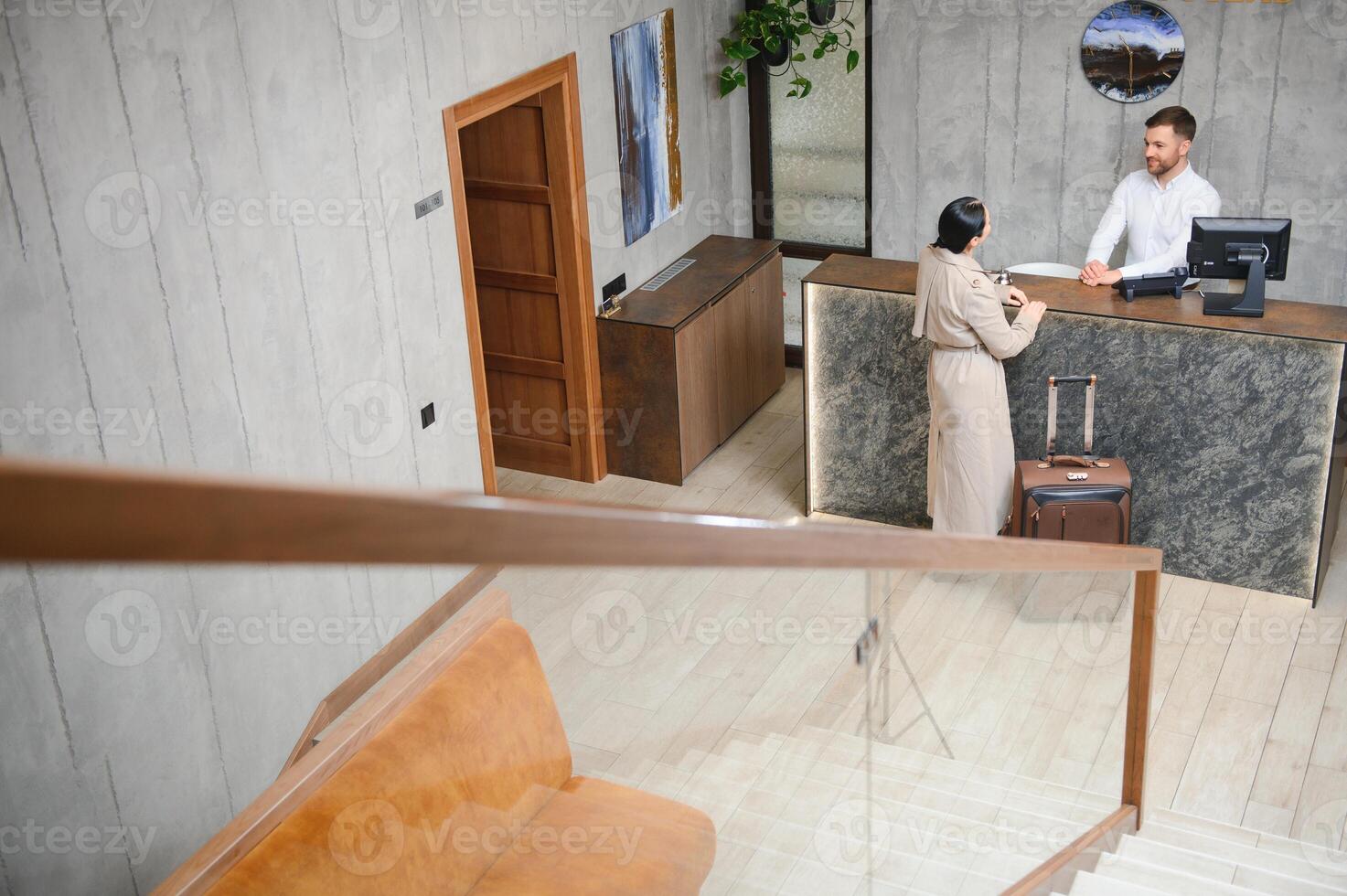 elegant bedrijf vrouw met reizen trolley bagage in hotel lobby foto