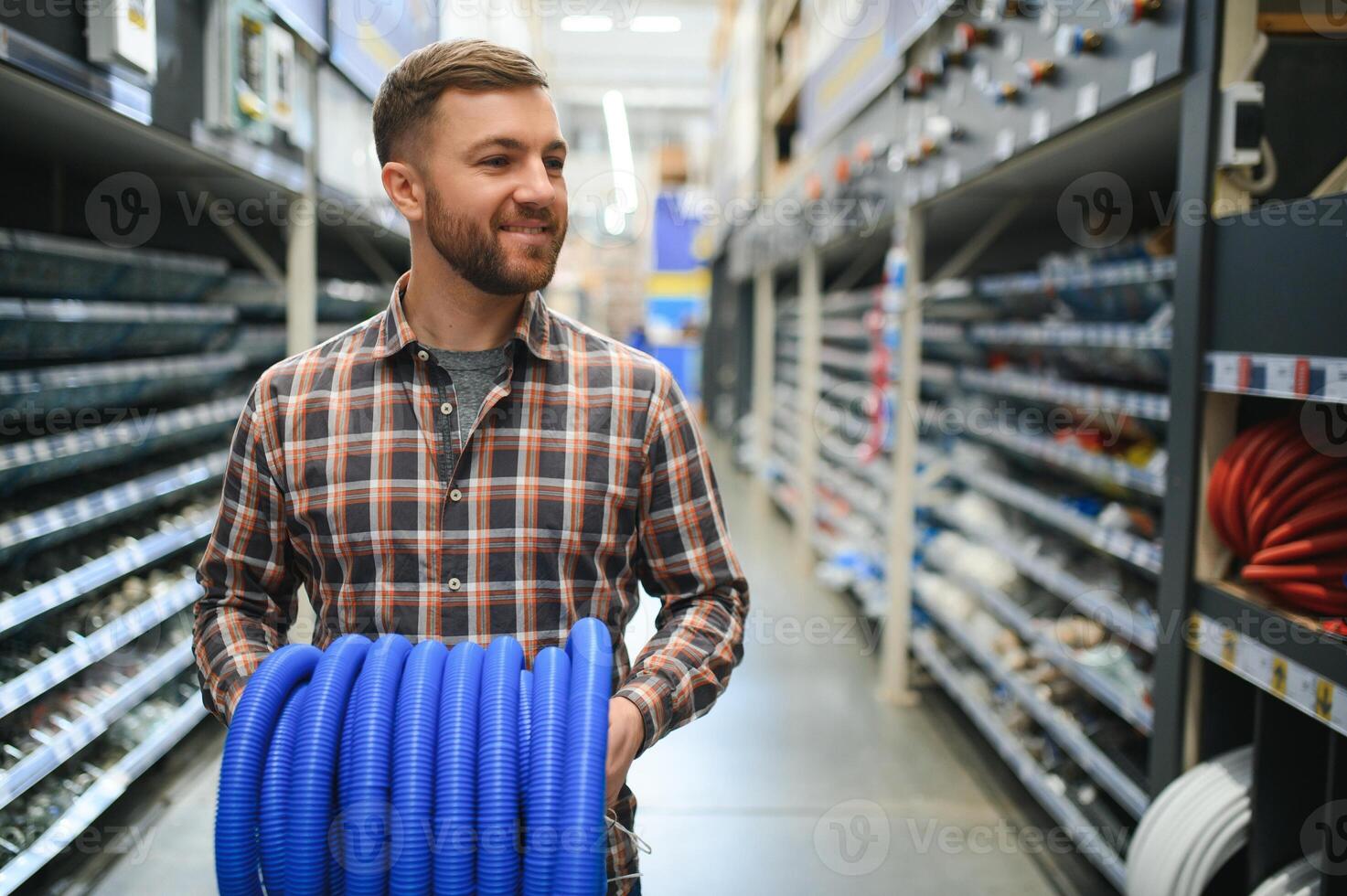 knap Mens kiezen riool pijpen staand in de buurt de vitrine van de loodgieter winkel foto