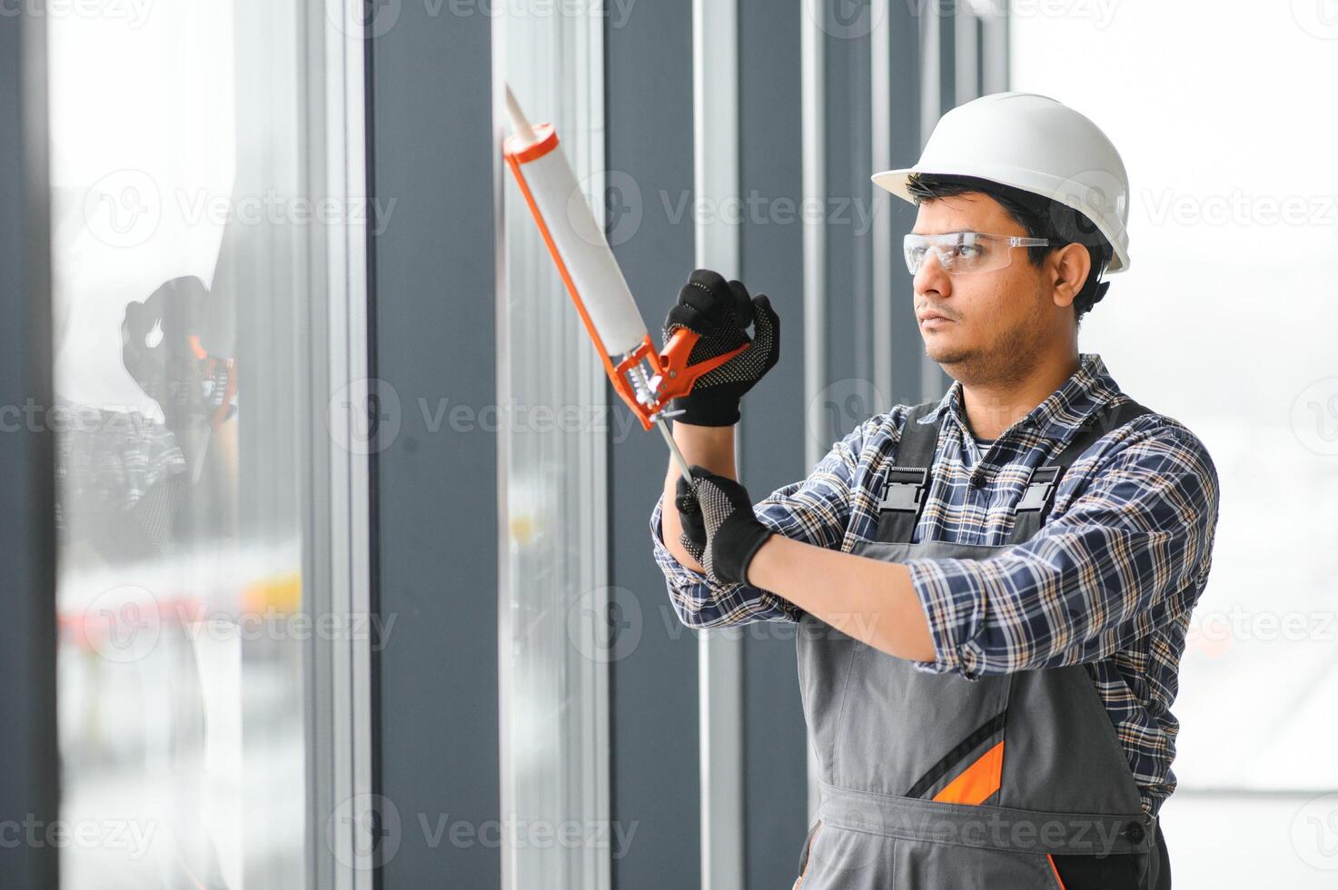 werkman in overall installeren of aanpassen plastic ramen foto