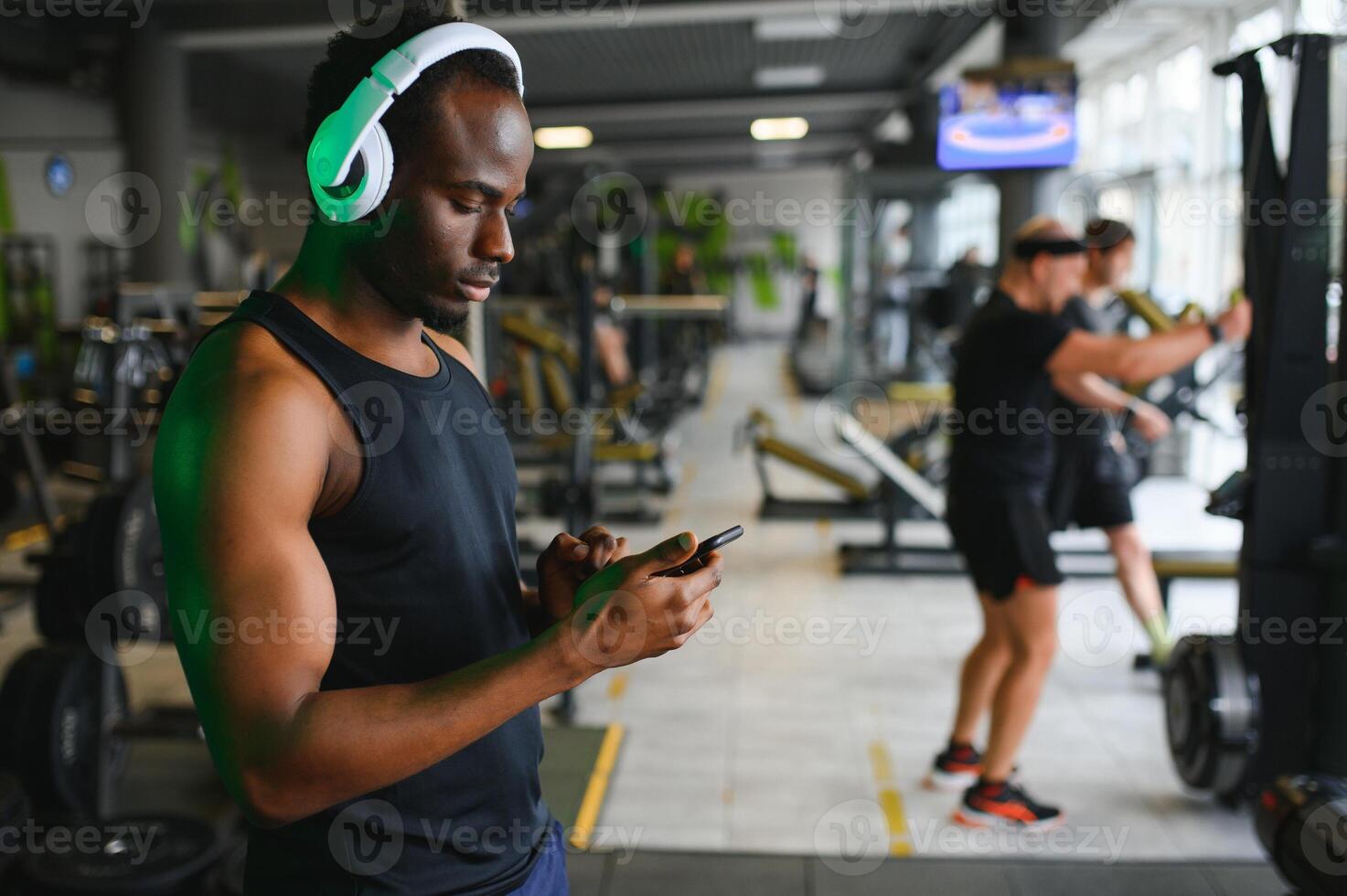 Afrikaanse Amerikaans Mens luisteren motiverende muziek- over- hoofdtelefoons verbeteren kwaliteit van training foto