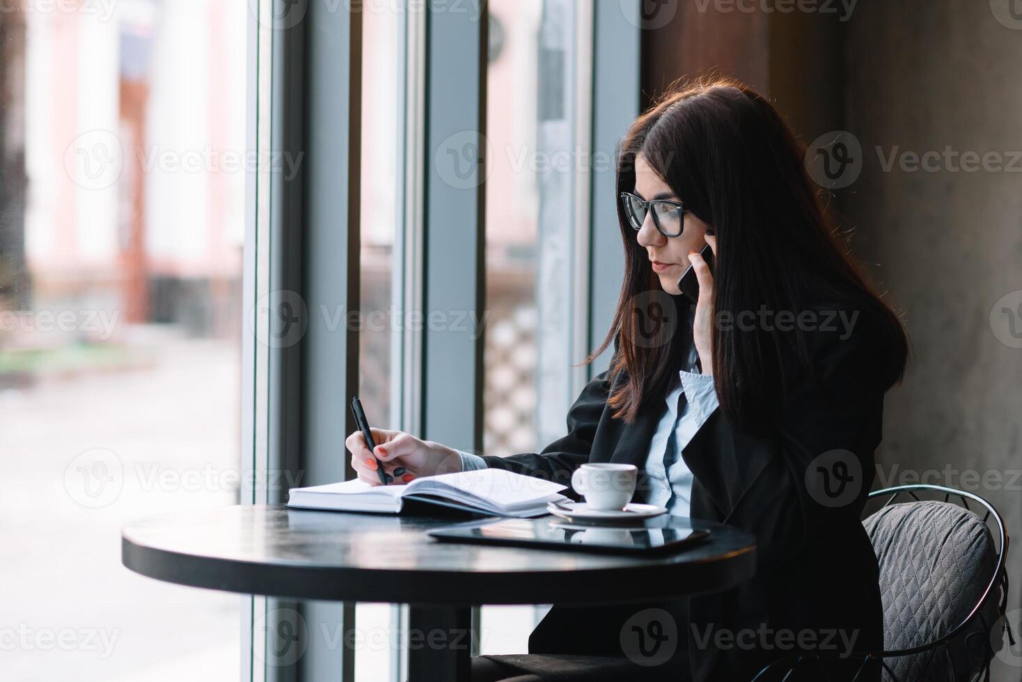 jong zakenvrouw pratend Aan de telefoon in koffie winkel. foto