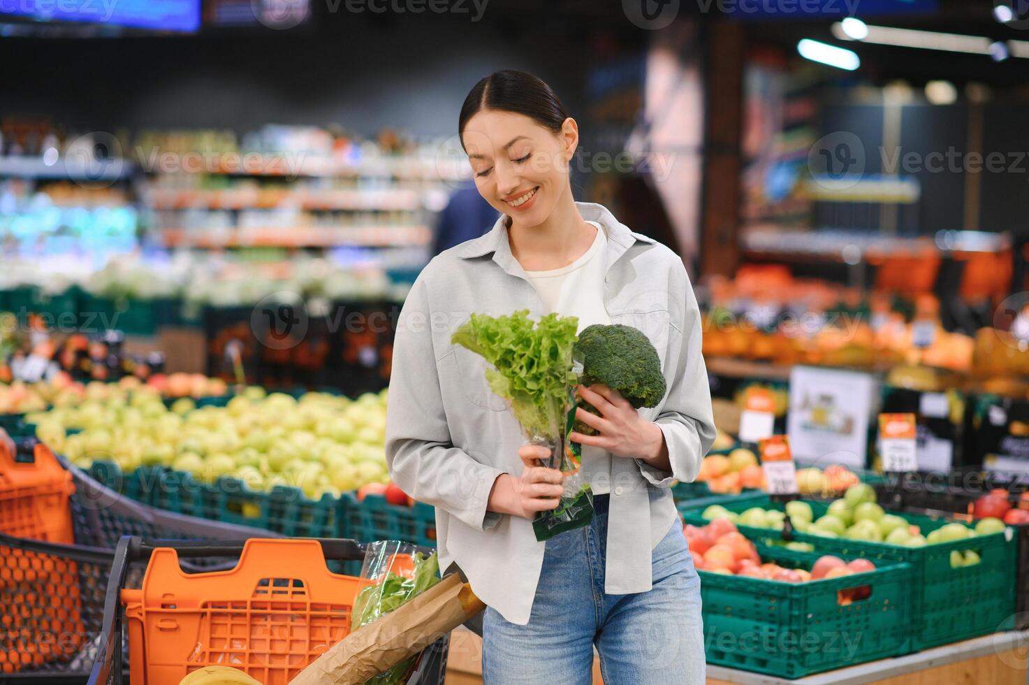 jong vrouw buying groenten Bij kruidenier markt foto